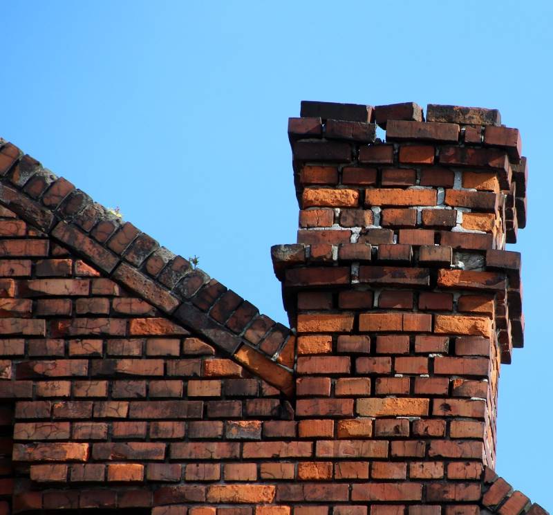Damaged chimney on an Opa-Locka home showing cracks and missing mortar